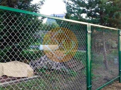 Забор с зелеными столбами из сетки рабицы для дачи